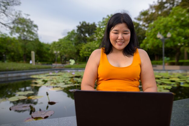 Ritratto di bella donna asiatica in sovrappeso rilassante presso il parco della città di Bangkok, Thailandia