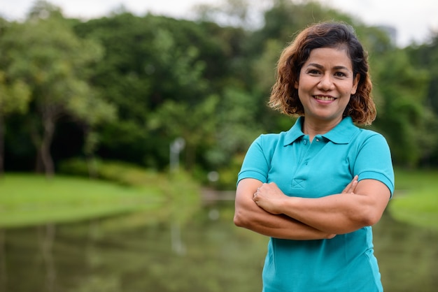 Ritratto di bella donna asiatica matura che si rilassa al parco all'aperto