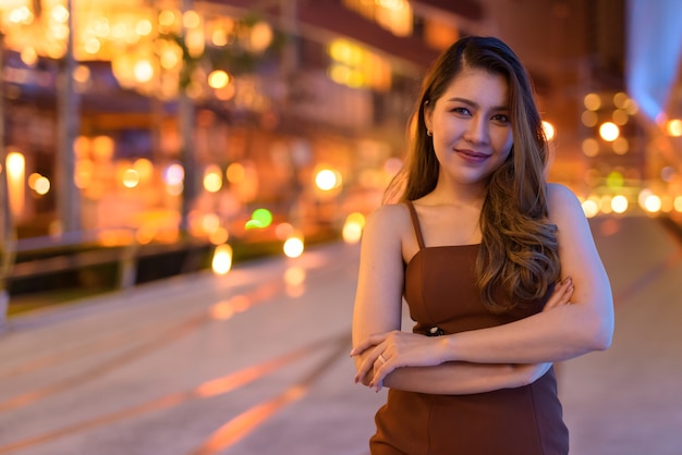 Ritratto di bella donna asiatica sorridente all'aperto a Bangkok, in Thailandia durante la notte