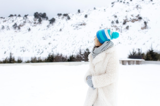 Ritratto di bella donna bionda felice con neve nella natura invernale