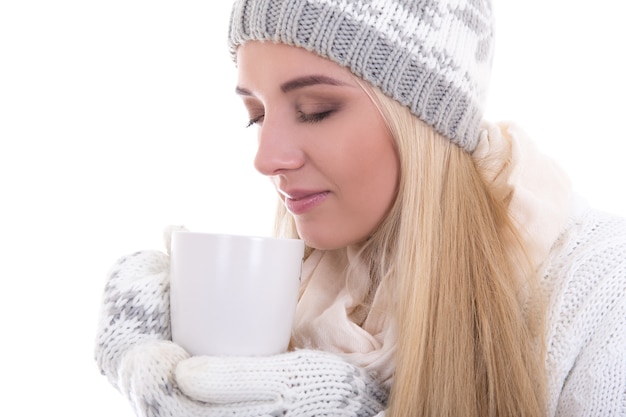 ritratto di bella donna carina in abiti invernali con tazza di tè o caffè isolato su bianco