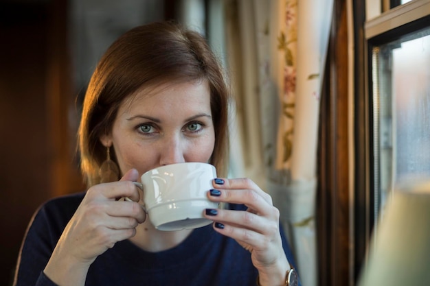 Ritratto di bella donna che mangia caffè