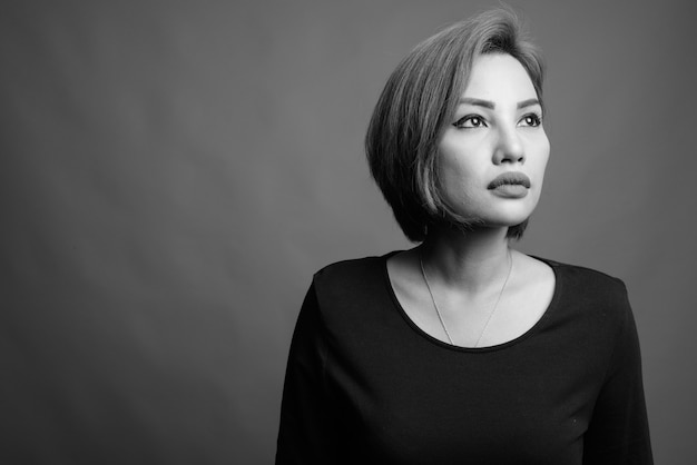 Ritratto di bella donna d'affari asiatica su grigio in bianco e nero