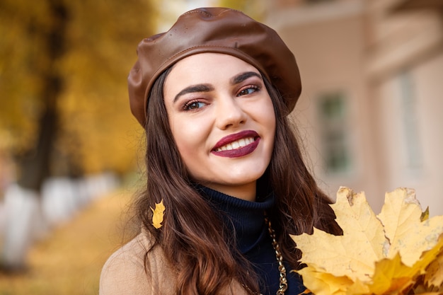 Ritratto di bella donna europea alla moda in autunno. La donna indossa berretto in pelle marrone