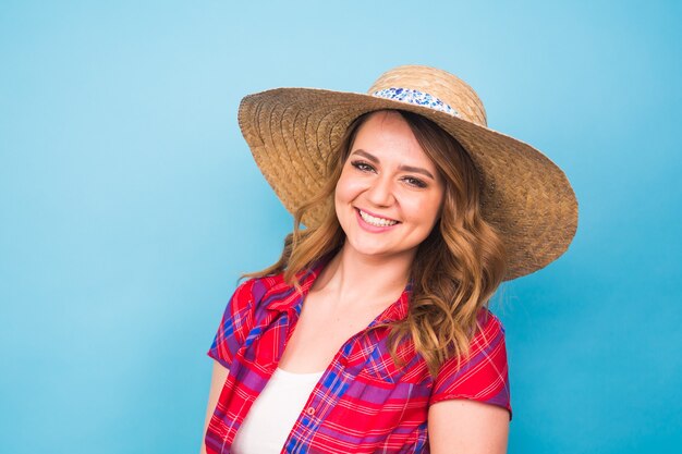 Ritratto di bella donna in cappello su sfondo blu e copia spazio