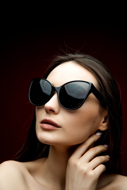 Ritratto di bella donna in occhiali da sole a forma di cuore