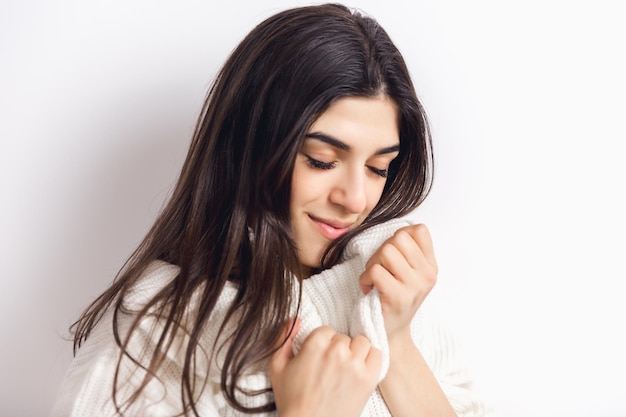 Ritratto di bella donna isolata su sfondo bianco studio. Comfort, caldo in inverno concetto