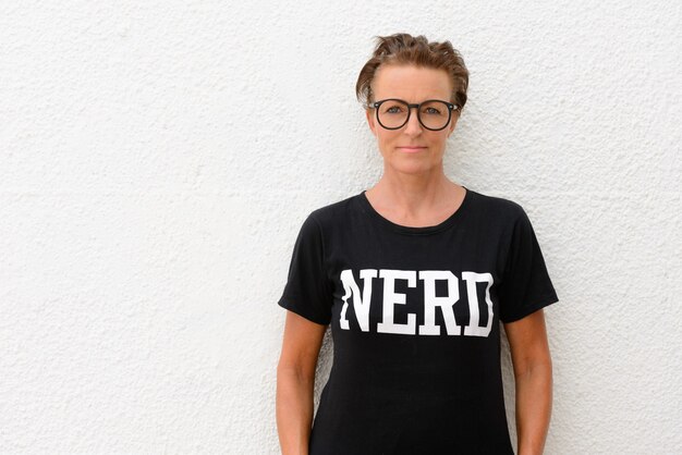 Ritratto di bella donna matura nerd indossando occhiali isolati