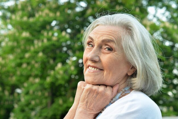 Ritratto di bella donna sorridente senior in posa nel parco di primavera