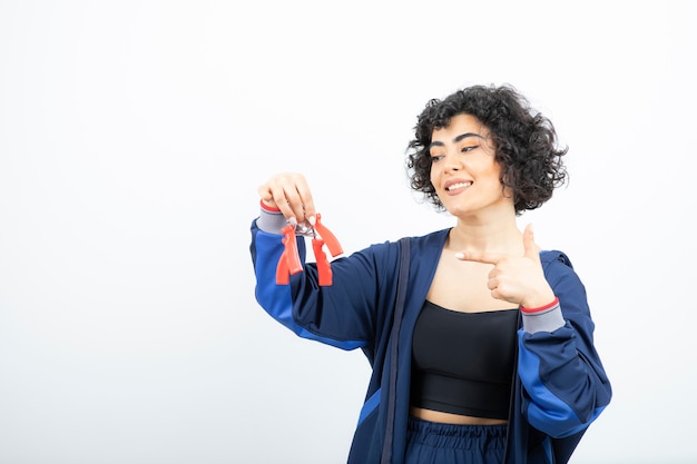 Ritratto di bella donna sportiva che tiene gli espansori della mano.