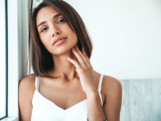 Ritratto di bella donna vestita di pigiama bianco.