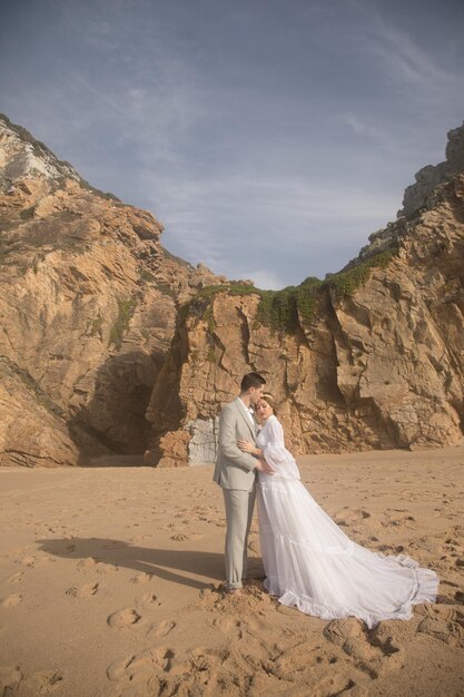 Ritratto di bella giovane coppia di sposi sulla spiaggia