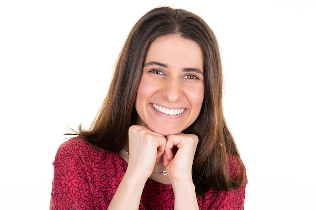 Ritratto di bella giovane donna carina Ragazza carina sorridente con i capelli lunghi girato in studio con le mani chiuse sotto il mento isolato su sfondo bianco