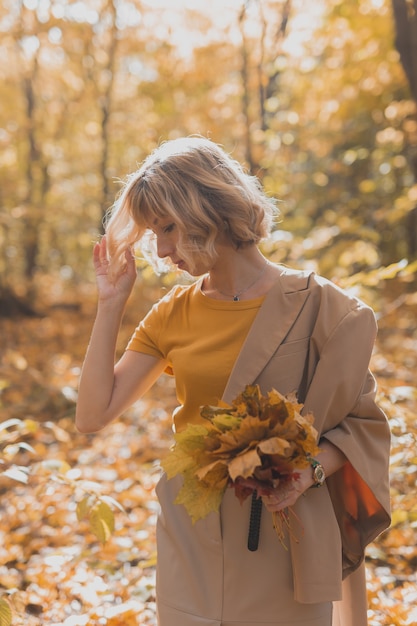 Ritratto di bella giovane donna che cammina all'aperto in autunno. Stagione autunnale e concetto di ragazza alla moda.