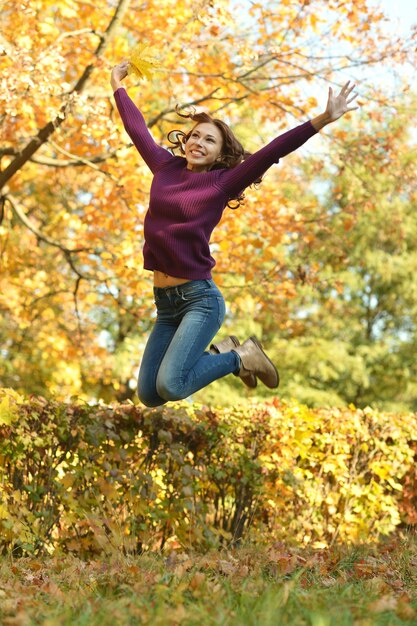 Ritratto di bella giovane donna felice in autunno park