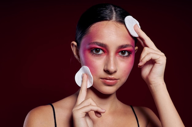 Ritratto di bella giovane donna rosa trucco viso in posa aspetto attraente cura della pelle primo piano inalterato