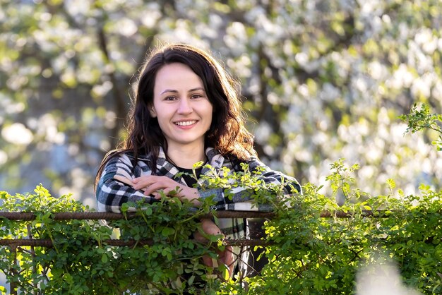 Ritratto di bella giovane donna sorridente felicemente rilassante all'aperto in una giornata di sole primaverile.