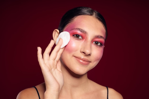 Ritratto di bella giovane donna trucco luminoso in posa moda emozioni cosmetici sfondo rosa inalterato