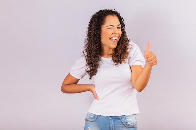 Ritratto di bella giovane ragazza afro sorridente pollici in su. Ragazza brasiliana.