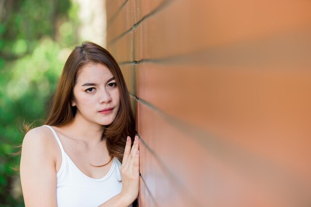 Ritratto di bella ragazza asiatica chic indossare abito nero posa per scattare una foto sul muro di mattoni Stile di vita della gente della Tailandia teenager Concetto felice della donna moderna