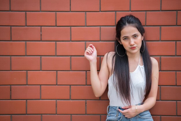 Ritratto di bella ragazza asiatica chic posa per scattare una foto sullo sfondo della pareteStile di vita della gente della Tailandia adolescenteDonna moderna concetto feliceStile punk rock