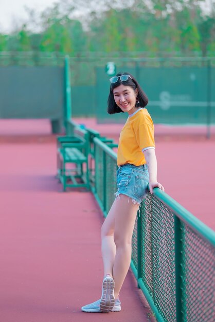 Ritratto di bella ragazza asiatica chic posa per scattare una fotoStile di vita di giovani persone thailandesiDonna moderna concetto feliceTennis couse tono pastello