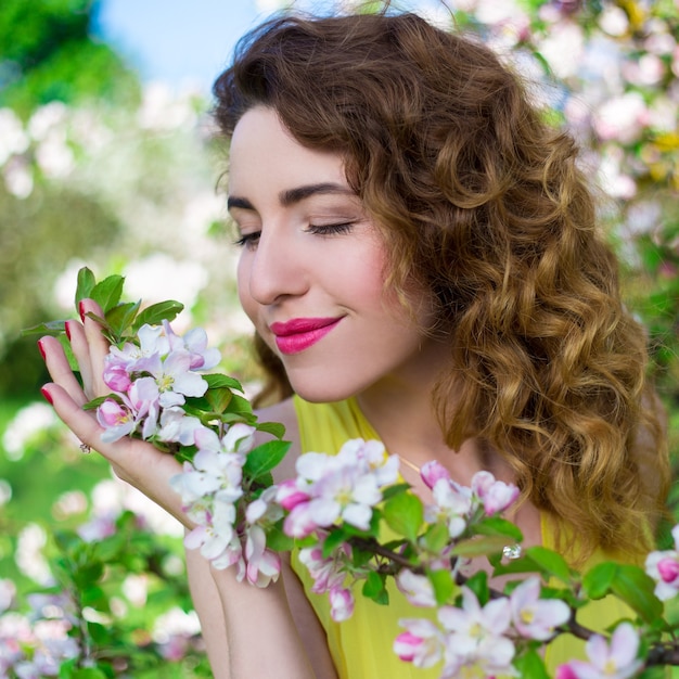 Ritratto di bella ragazza felice nel giardino estivo in fiore