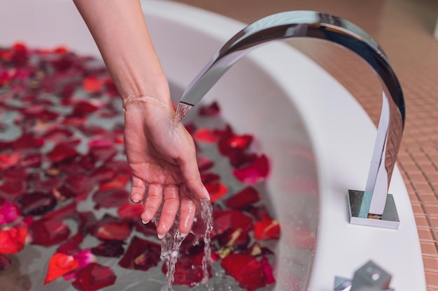 Ritratto di bella ragazza pinup caldo capelli rossi prendendo un bagno rilassante con petali di fiori su sfondo bianco spazio copia all'aperto