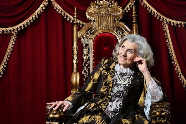 Ritratto di bella regina senior sorpresa sul trono