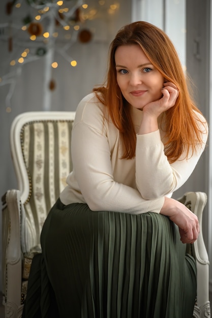 Ritratto di bellezza della donna caucasica di tipo scandinavo finlandese che si siede sulla sedia