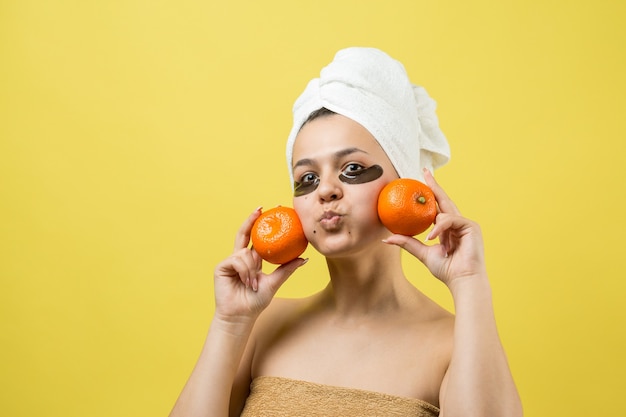 Ritratto di bellezza di donna in asciugamano bianco sulla testa con maschera nutriente d'oro sul viso