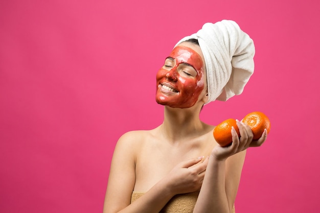 Ritratto di bellezza di donna in asciugamano bianco sulla testa con maschera nutriente d'oro sul viso