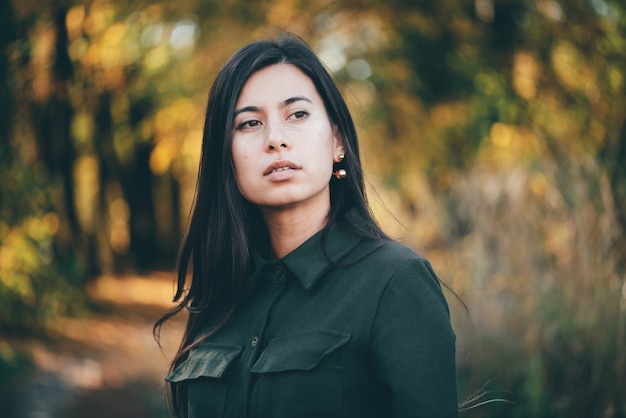 Ritratto di bellezza femminile circondato da fogliame vivido.