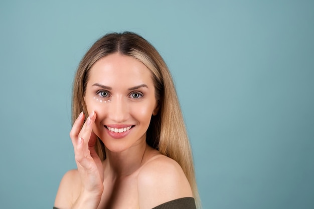 Ritratto di bellezza in primo piano di una donna in topless con pelle perfetta e trucco naturale, con punti crema antietà per idratare e rassodare la pelle sotto gli occhi