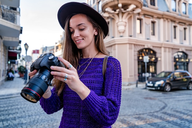 Ritratto di bello fotografo felice con la macchina fotografica alla via