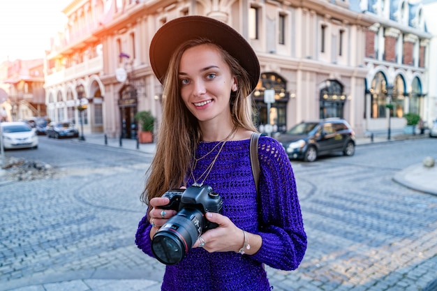 Ritratto di bello fotografo felice con la macchina fotografica alla via