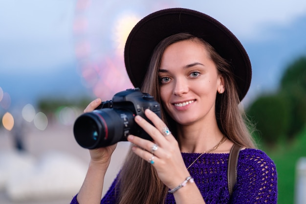 Ritratto di bello fotografo felice con la macchina fotografica alla via