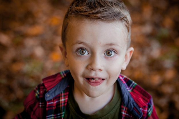 Ritratto di bello ragazzino sorridente alla sosta di autunno