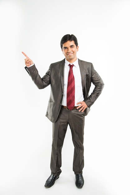 Ritratto di bello uomo d'affari asiatico o indiano in piedi isolato su sfondo bianco
