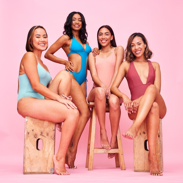 Ritratto di bikini e gruppo di donne su sgabello in studio isolato su uno sfondo rosa Costumi da bagno felici e amici con inclusione e diversità di positività corporea nella moda estiva in vacanza al mare