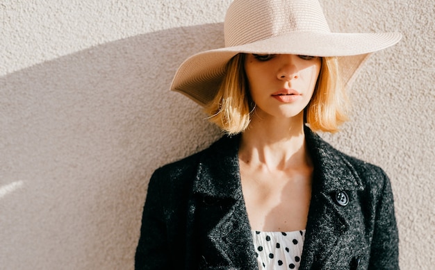 Ritratto di cappello e giacca womanin elegante alla moda capelli corti biondi