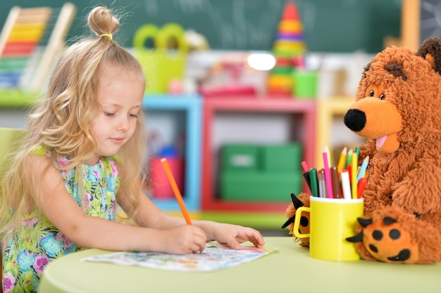 Ritratto di carina bella bambina che disegna al tavolo