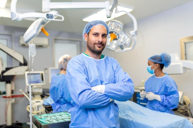 Ritratto di chirurgo maschio in piedi con le braccia incrociate in sala operatoria in ospedale I chirurghi del team stanno eseguendo un'operazione un medico di mezza età sta guardando la fotocamera in una moderna sala operatoria