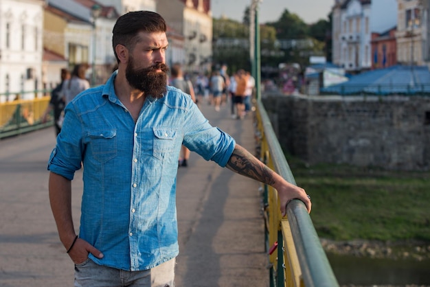 Ritratto di città dell'uomo. Camminare per le strade della città. Pantaloni a vita bassa all'aperto.