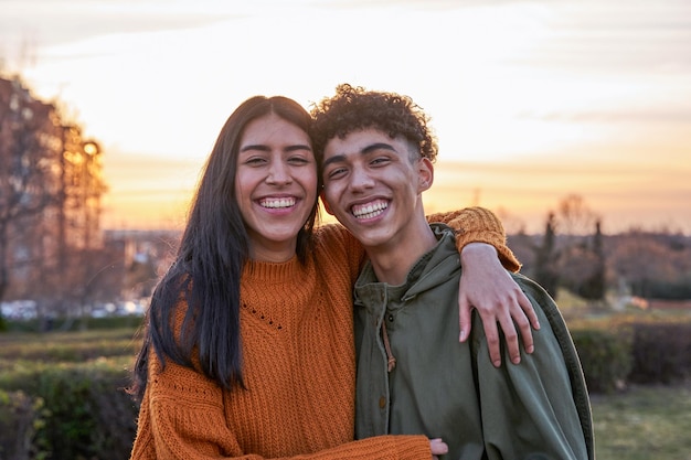 Ritratto di coppia adolescente latina sorridente al tramonto