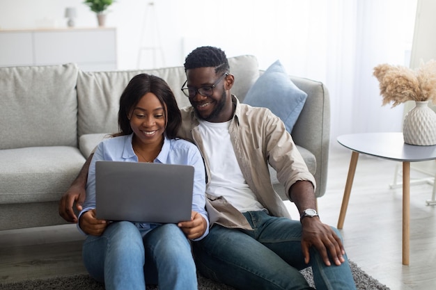 Ritratto di coppia afroamericana che utilizza il laptop a casa