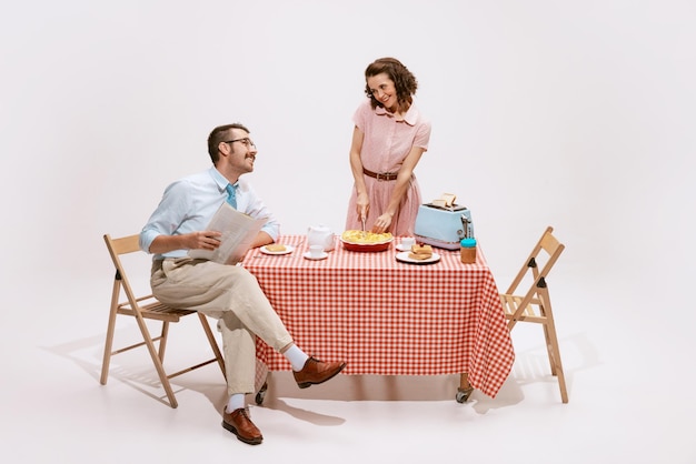 Ritratto di coppia amorosa uomo e donna che mangiano colazione insieme isolato su bianco studio