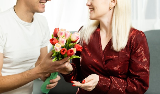 ritratto di coppia felice, marito e moglie con bouquet di fiori primaverili.