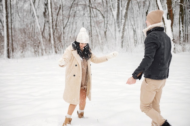 Ritratto di coppia romantica che cammina nella foresta al giorno d'inverno
