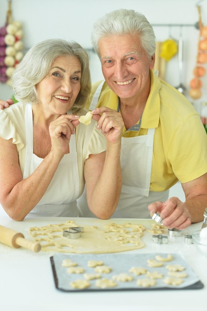 Ritratto di coppia senior che cuoce in cucina a casa